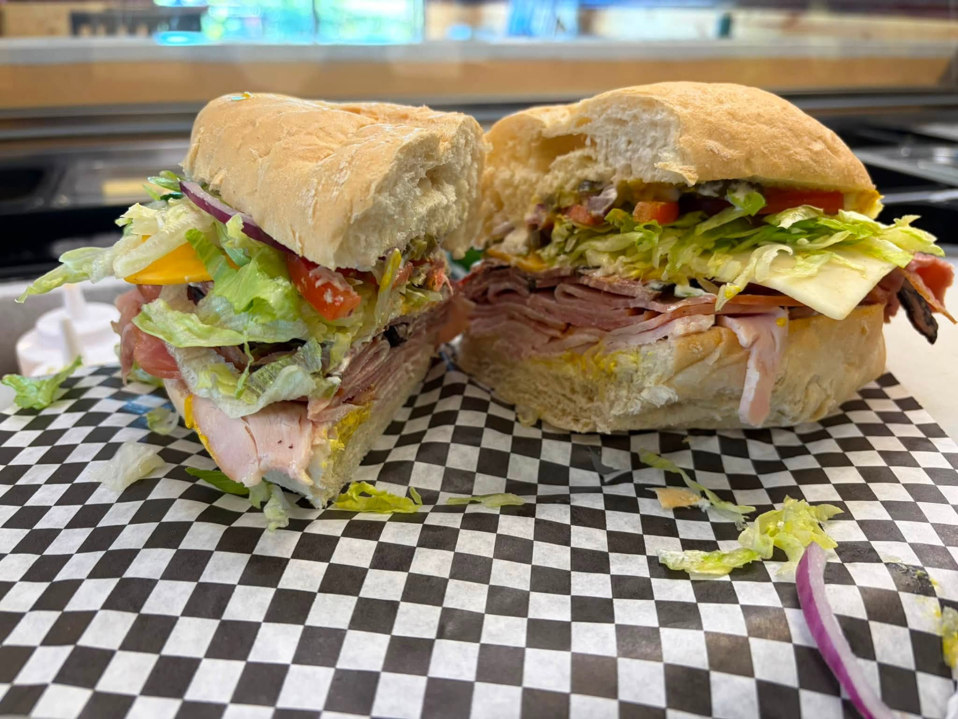 Loaded cold sub cut in half on checkered paper